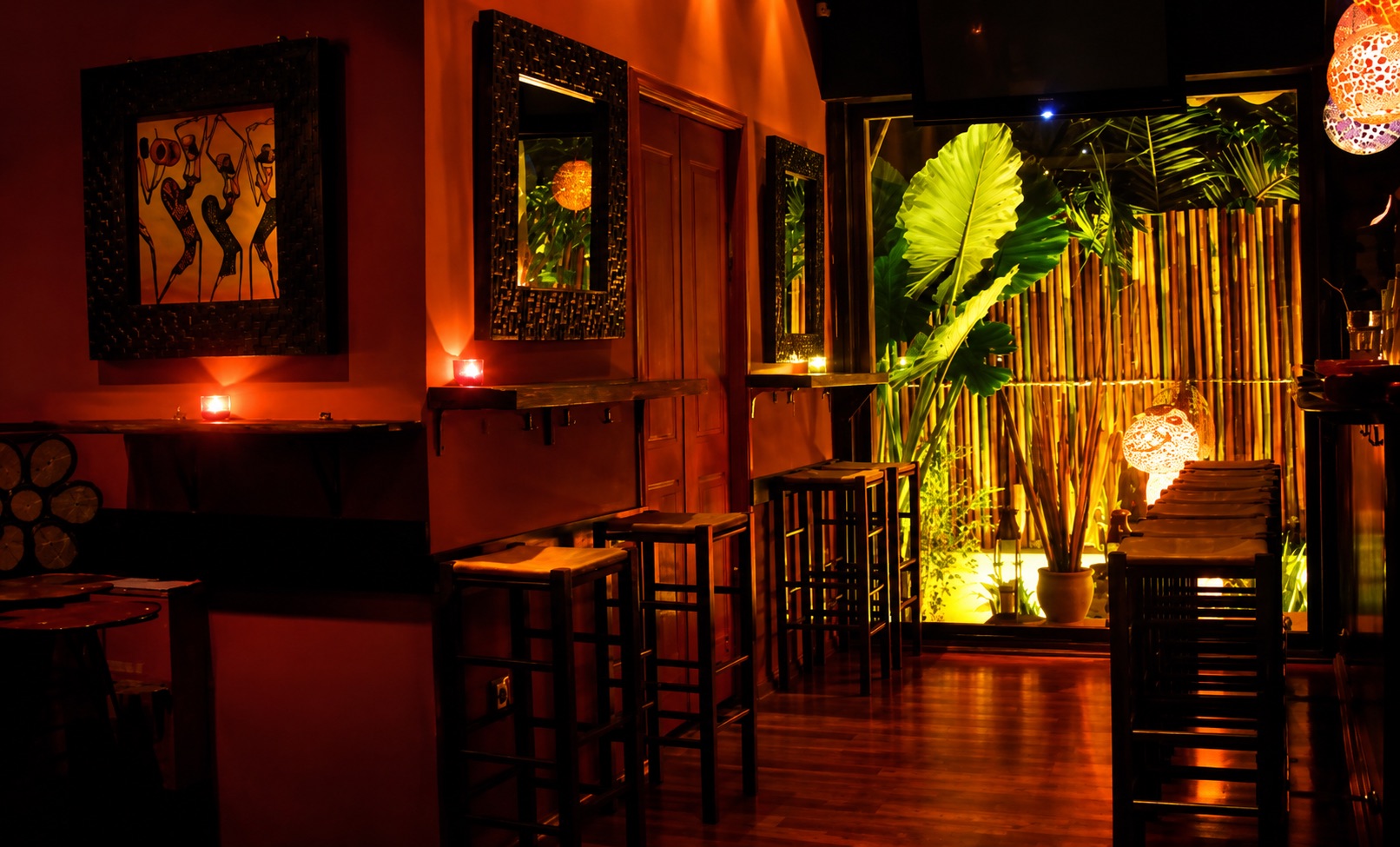 The lit interior of Mousiko Kafeneio in Nea Smyrni, with wooden tables and warm lights